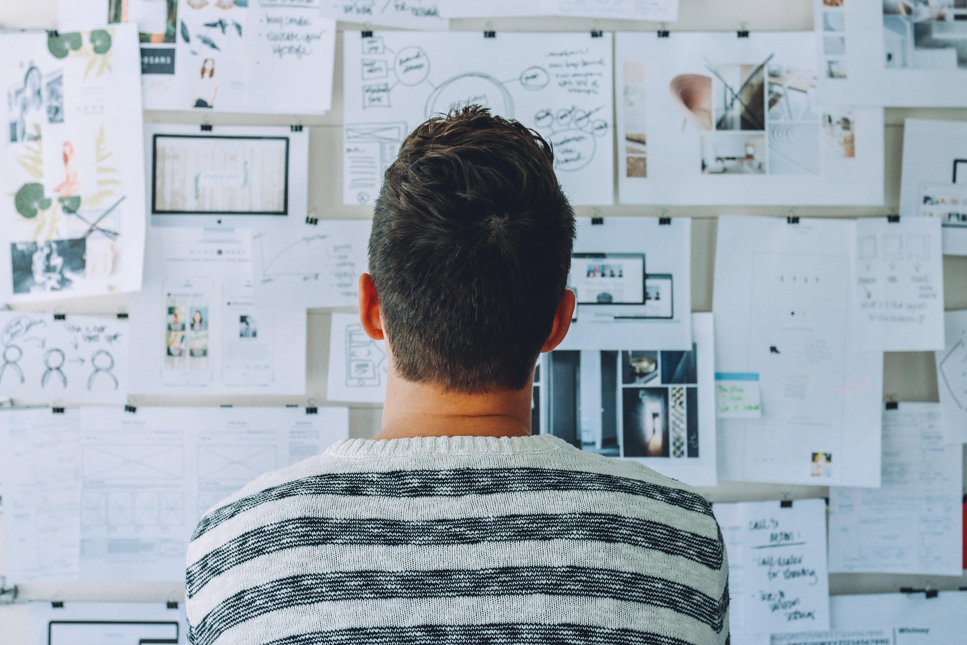 Design process wall with wireframes and reference material